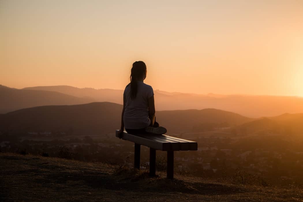 Woman sitting on bench practising breathing techniques 