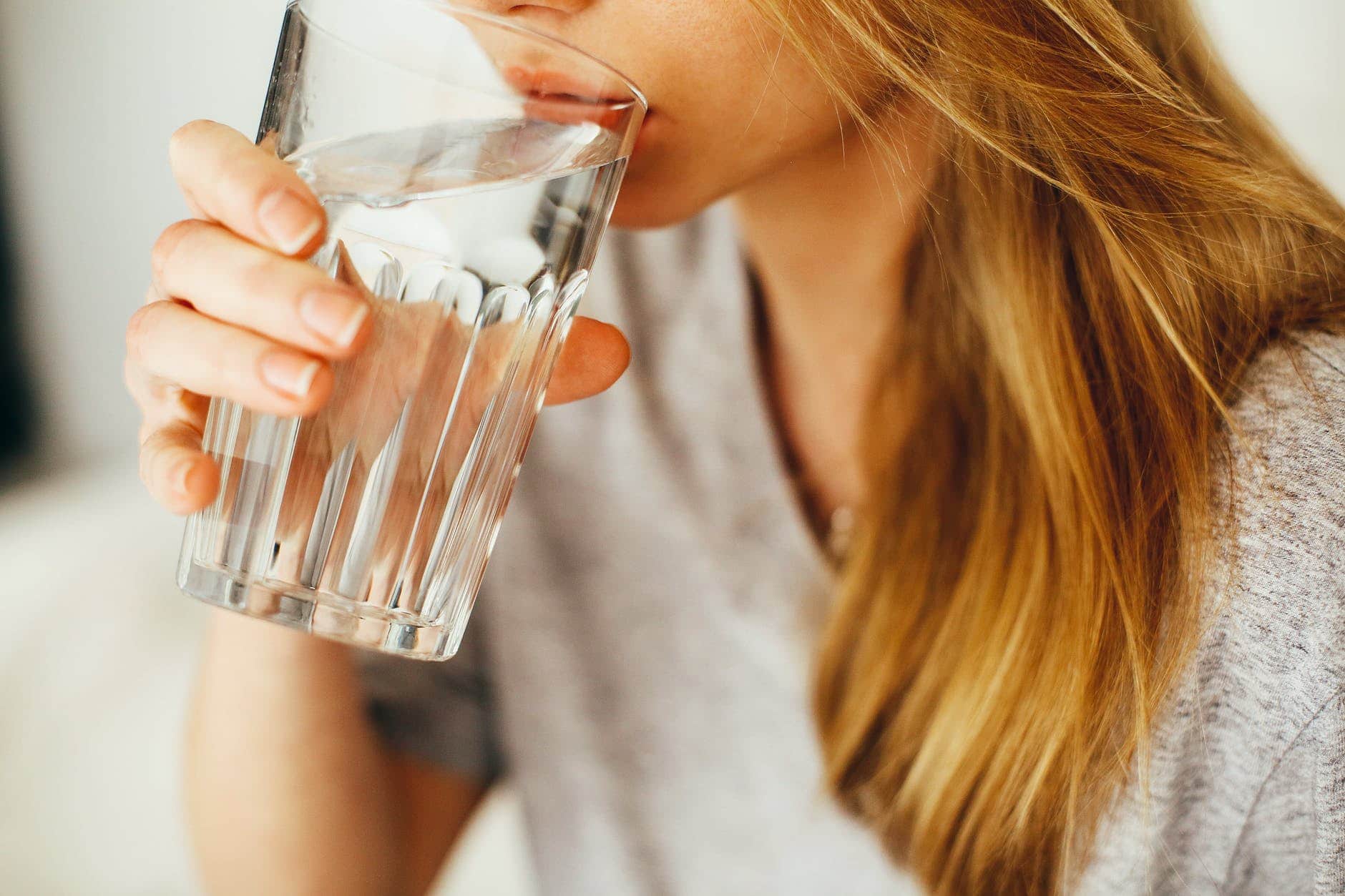 Woman taking a sip from a glass of water
