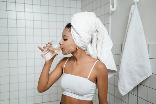 Woman wearing a face mask and drinking water